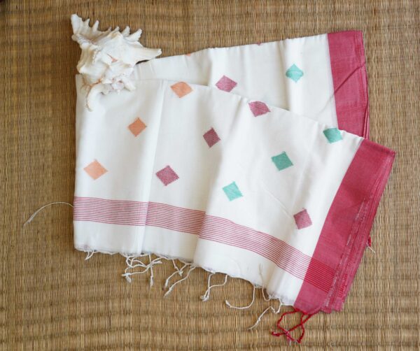 A pure cotton handwoven red and white Bengali Jamdani saree laid out on a mat, perfect for Durga Puja or Saraswati Puja