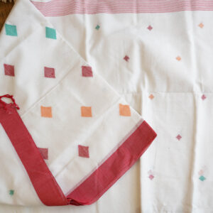 A pure cotton handwoven red and white Bengali Jamdani saree laid out on a mat, perfect for Durga Puja or Saraswati Puja