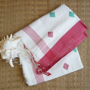 A pure cotton handwoven red and white Bengali Jamdani saree laid out on a mat, perfect for Durga Puja or Saraswati Puja
