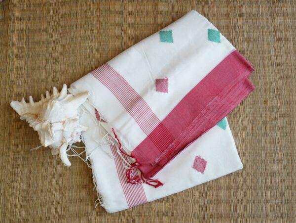 A pure cotton handwoven red and white Bengali Jamdani saree laid out on a mat, perfect for Durga Puja or Saraswati Puja