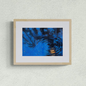 Dry pastel painting of moonlight reflected on rippling blue water, in an abstract circular form with amber highlights, by Saikat Mondal.